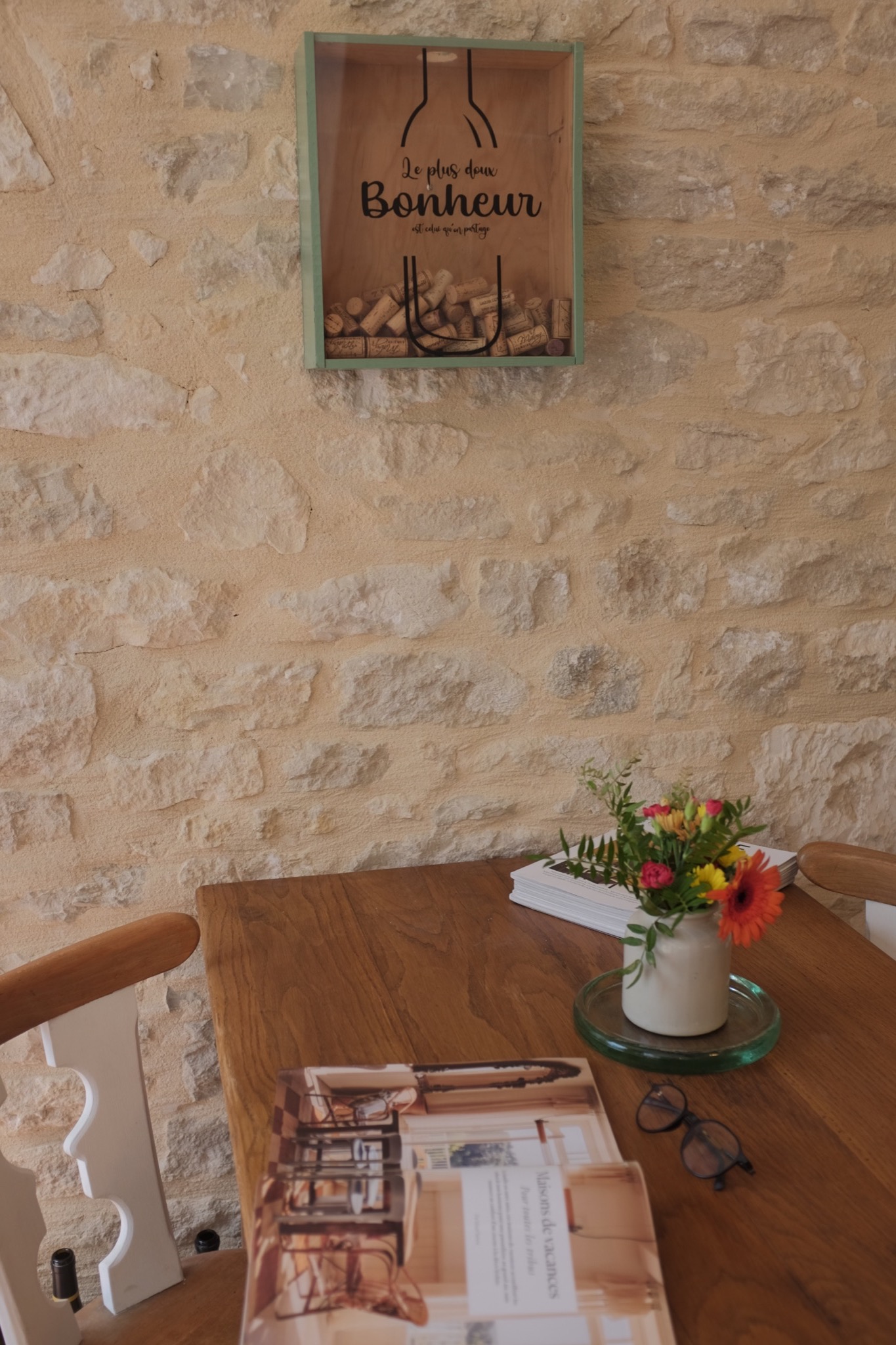 Cork-filled Bonheur frame above the dining table on a limestone wall