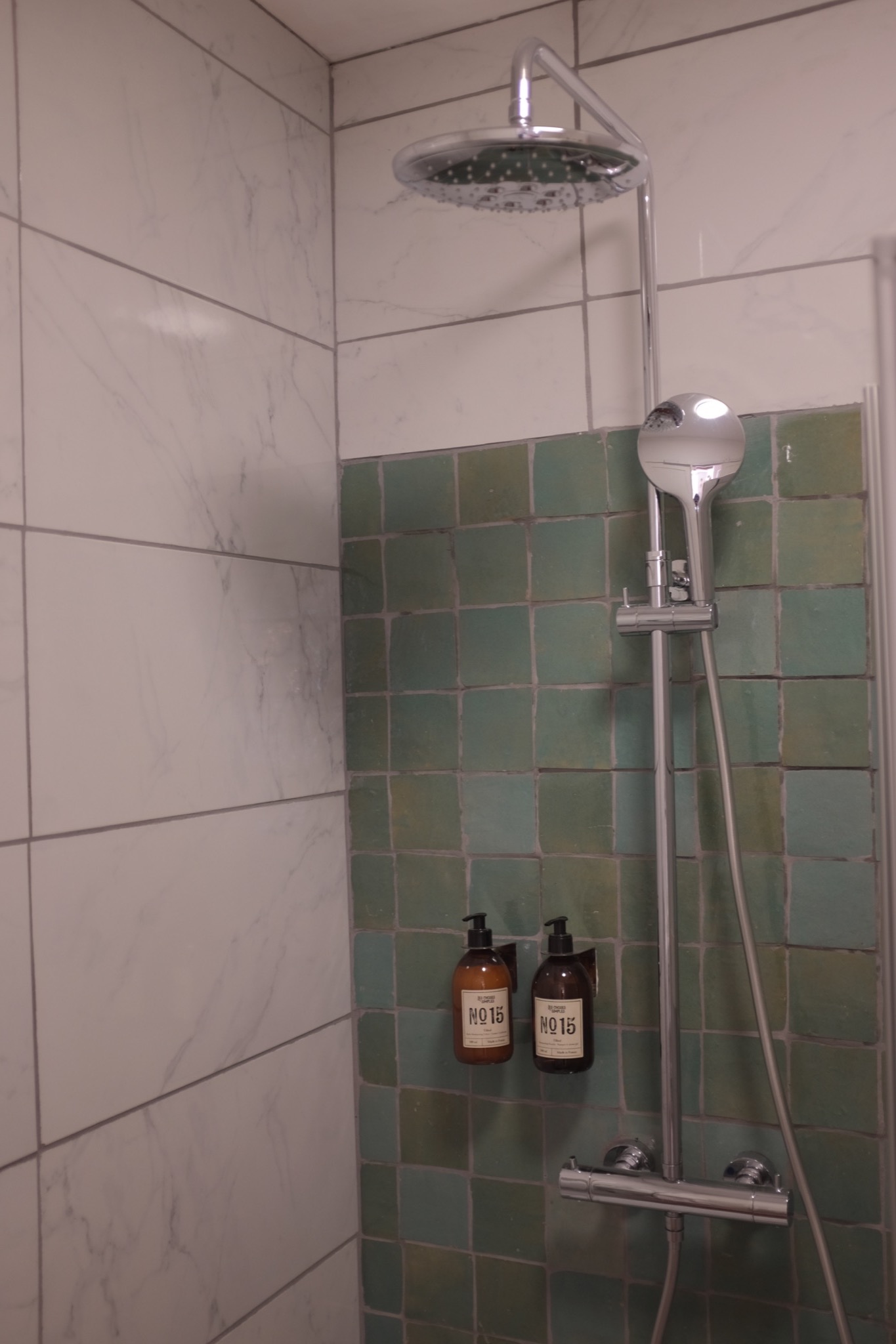 Walk-in rain shower with green zellige and marble tile