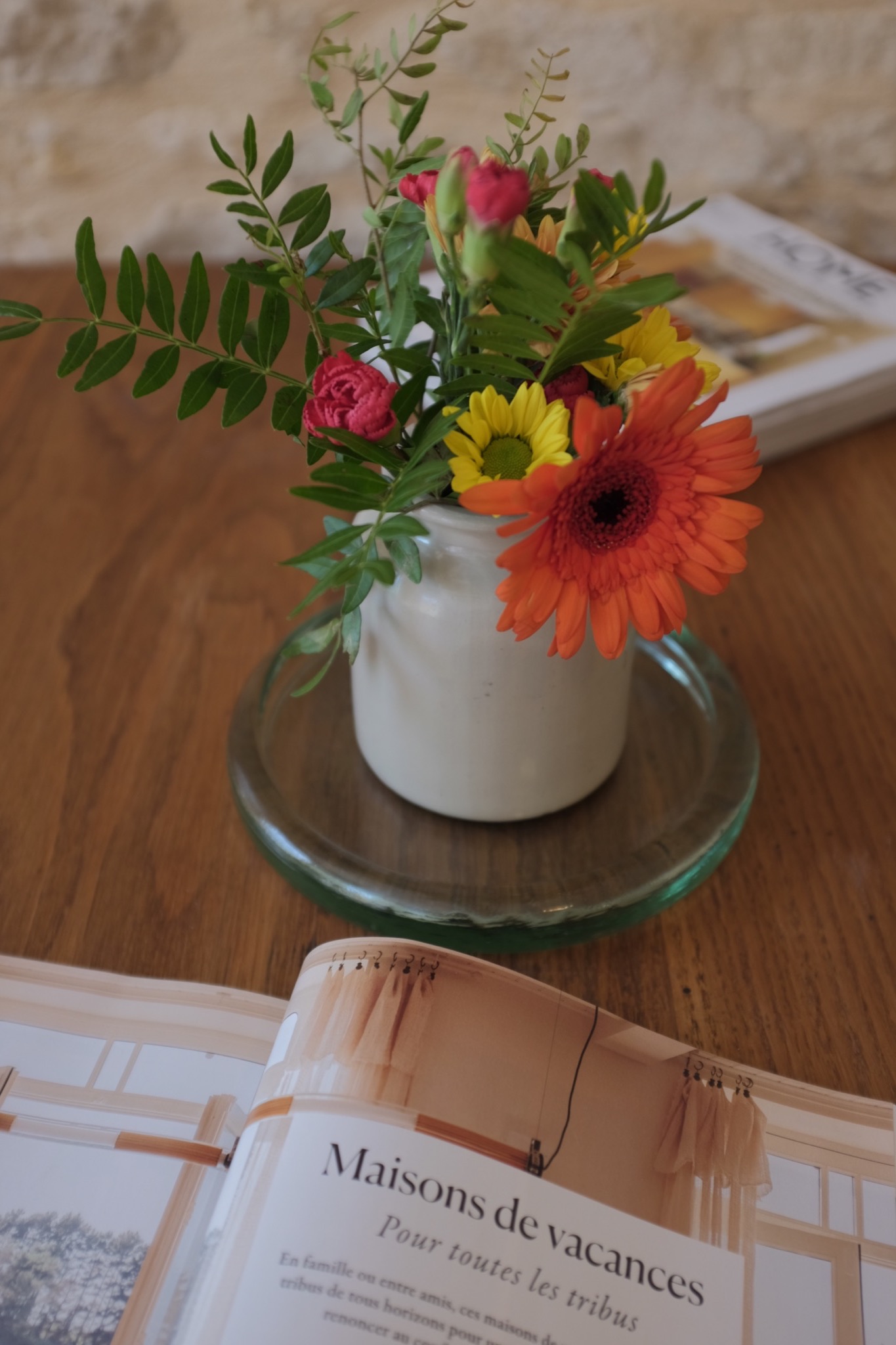 Gerbera and rose posy on the dining table beside an open magazine