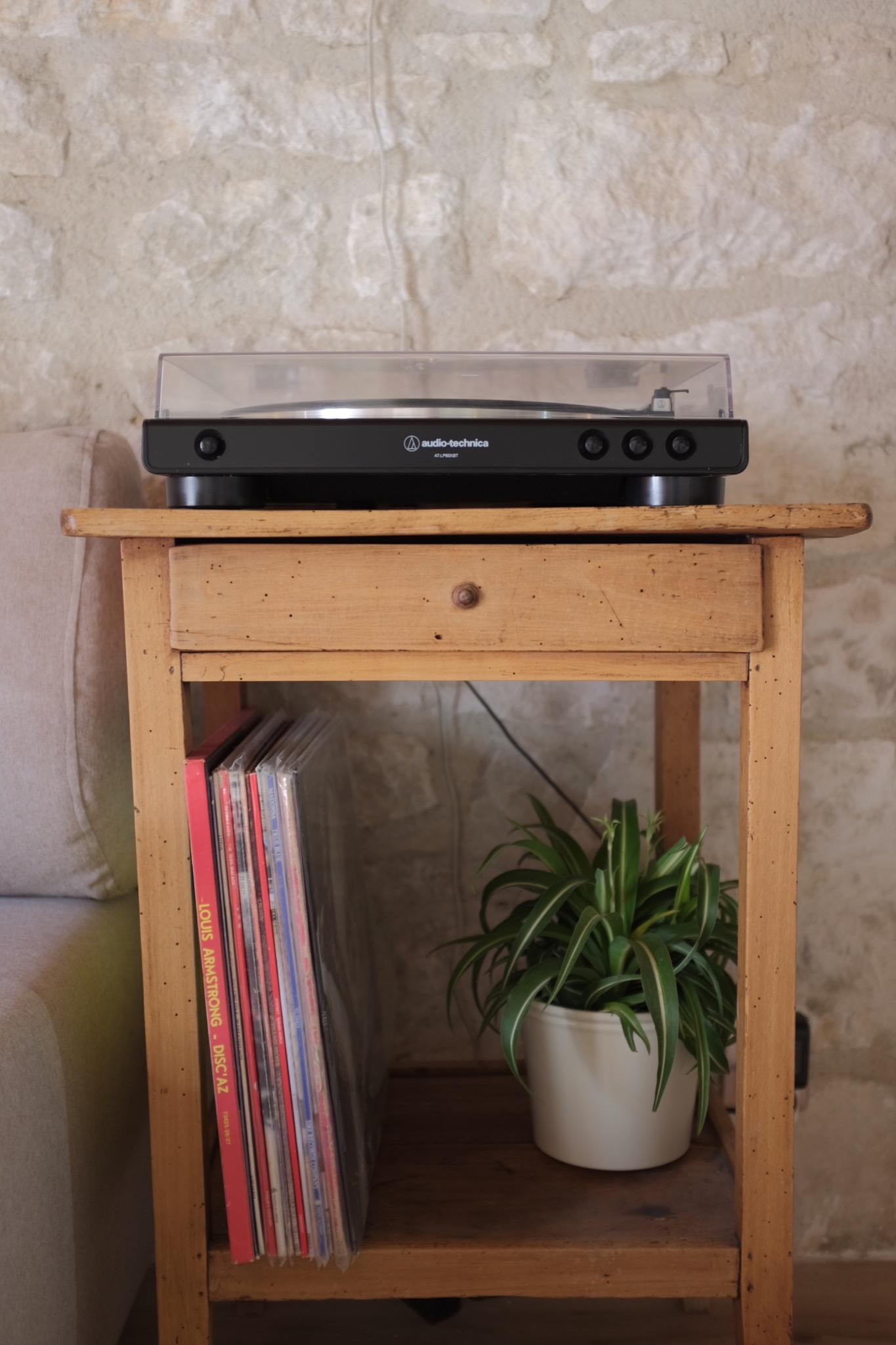 Audio-Technica turntable and vinyl records on a rustic side table