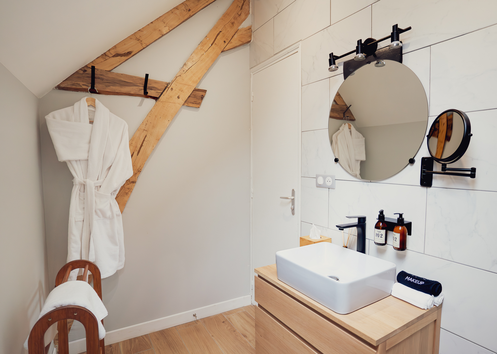 Bathroom vanity with marble tile and bathrobe
