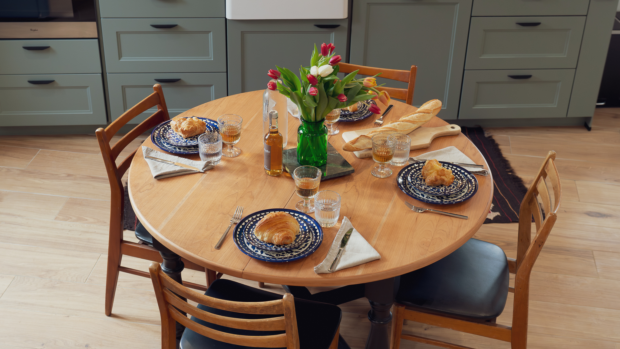 Round dining table with pastries and tulips